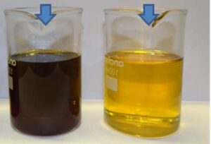 a beaker of black waste oil on the left, a beaker of the same oil re-refined, lightly colored, on the right