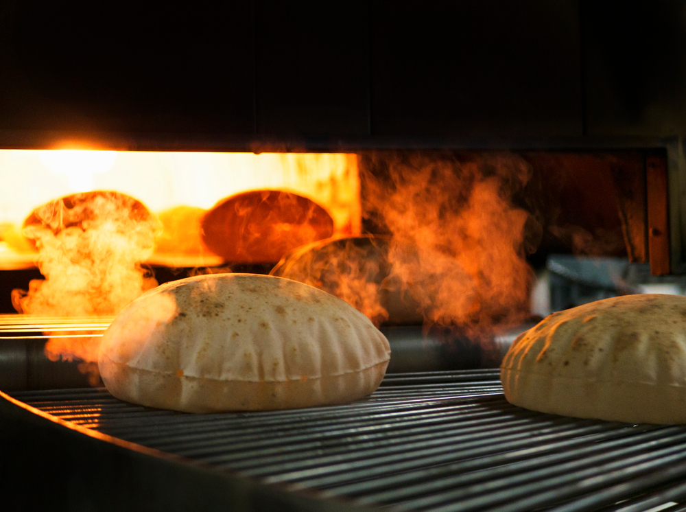 Fresh pita taken from oven - article about industrial white oils for heat transfer and food-grade lubrication