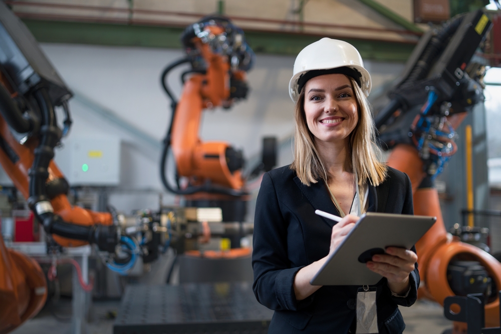 Female chief engineer in a modern industrial factory using a tablet - article about the future of specialty oils